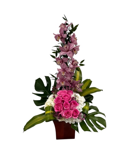 A breathtaking arrangement of lush pink cymbidium orchids, fresh hydrangea, and romantic pink roses.
