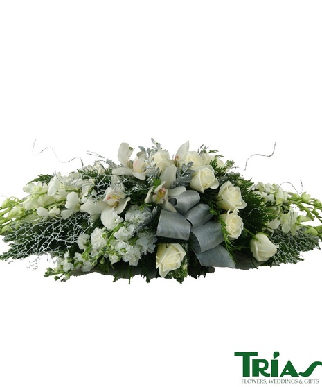 Holiday centerpiece with white dendrobium orchids, white cymbidium orchids, white roses, white stocks, silver coral ferns, silver leather leaves and silver ribbon